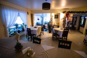 une salle à manger avec des tables et des chaises dans un restaurant dans l'établissement Pensiunea Bradului, à Colibiţa