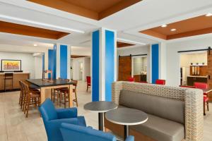 eine Lobby mit einem Sofa, einem Tisch und Stühlen in der Unterkunft Holiday Inn Express Hotel & Suites Fort Myers East - The Forum, an IHG Hotel in Fort Myers
