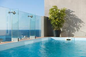 
a swimming pool with a blue tub and a blue shower curtain at Rosselli in Valletta
