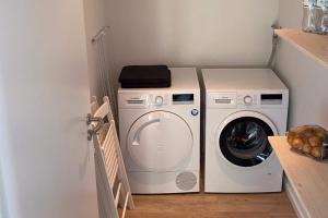 Waschmaschine und Trockner in einem kleinen Zimmer in der Unterkunft Yachtenkieker in Heiligenhafen
