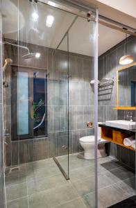 a bathroom with a glass shower and a toilet at Coast House Boutique Hotel in Nha Trang