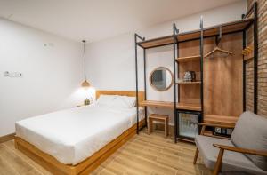 a bedroom with a bed and a chair at Coast House Boutique Hotel in Nha Trang