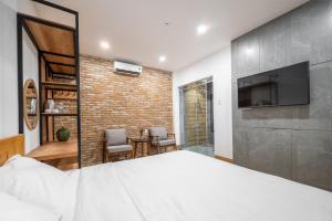 a bedroom with a large bed and a brick wall at Coast House Boutique Hotel in Nha Trang