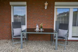 a table and two chairs sitting next to a brick wall at Haus Meeresglück Seehase in Dahme
