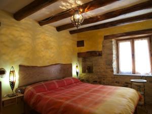 1 dormitorio con 1 cama en una habitación con techos de madera en O´Porron, en Sabiñánigo