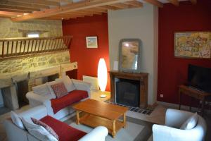 a living room with a couch and a fireplace at Les Chaufourniers / L'Ecurie in Crouay