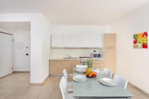 una cucina e una sala da pranzo con tavolo e sedie di Villa Marconi Apartment 4 a Golfo Aranci Altre 15 foto