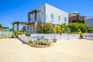 una casa bianca con fiori in un parcheggio di Villa Marconi Apartment 4 a Golfo Aranci