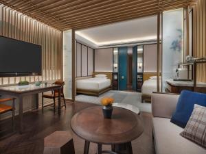 Park Hyatt Suzhou في سوتشو: غرفة معيشة مع أريكة وطاولة