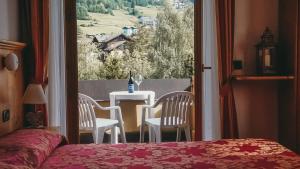 a bedroom with a table and chairs and a window at Residence Sci Sport in Bormio