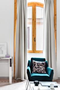 a blue chair sitting in front of a window at Casa di Lina in Rome