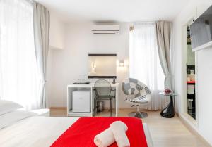 ein weißes Schlafzimmer mit einem roten Bett und einem Schreibtisch in der Unterkunft Palace Tartaglia in Split