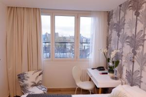 una piccola stanza con un tavolo e una finestra di Hôtel Moderna a Cherbourg en Cotentin