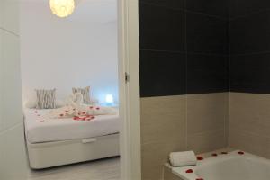 a bathroom with a bed and a tub and a shower at Luxury Hotel Suite Terrace & Parking in Málaga