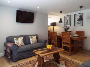 a living room with a couch and a table at Rosybank Cottage in Coldstream