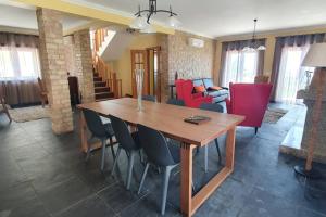 Una sala de estar con una mesa y sillas de madera. en Mia's House, en Casa Nova
