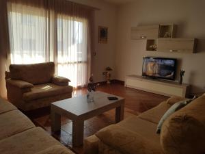 a living room with a couch and a table and a tv at Big apartment in Orikum