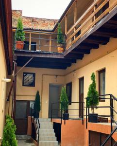 ein Gebäude mit Treppen und Topfpflanzen darauf in der Unterkunft ULLYSSES GUEST HOUSE in Braşov