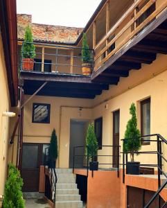 Un edificio con escaleras y plantas en macetas. en ULLYSSES GUEST HOUSE, en Brasov