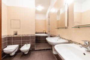 a bathroom with three sinks and two toilets at Rezidence Čertovka in Karlovy Vary