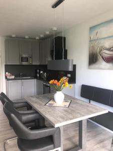 a kitchen with a table with a vase of flowers on it at Haus Bachwiesen in Grömitz