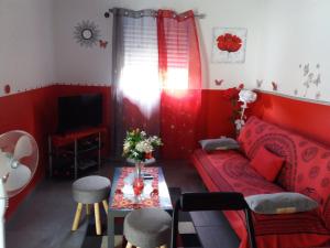 a red living room with a red couch and a table at Villa Bananier in Lamentin