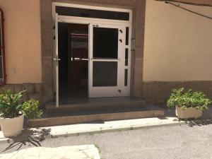 eine offene Tür mit zwei Topfpflanzen davor in der Unterkunft Edificio Mirasierra in Oropesa del Mar