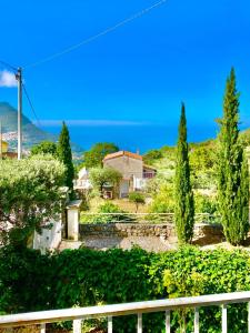 a house on a hill with trees and the ocean at Residenze Maremonti in Maratea