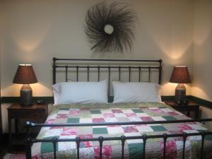 1 Schlafzimmer mit einem Bett mit einer Decke und 2 Lampen in der Unterkunft The Brafferton Inn in Gettysburg