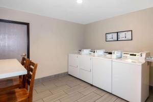 
a kitchen with white cabinets and white appliances at La Quinta Inn & Suites by Wyndham Las Vegas Nellis in Las Vegas
