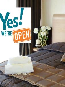 a sign on a bed that says yes were open at EH Rome Airport Euro House Hotels in Fiumicino