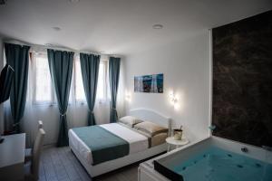 um quarto com uma cama e uma banheira em MERGELLINA AMORE e FANTASIA em Nápoles