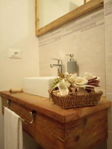 La salle de bains est pourvue d'un lavabo et d'un panier sur un comptoir. dans l'établissement Da Valentina, à Castelfondo