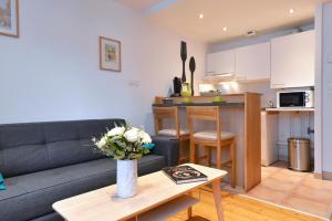 un soggiorno e una cucina con divano e tavolo di Appartement Le cosy de la Petite Venise a Colmar