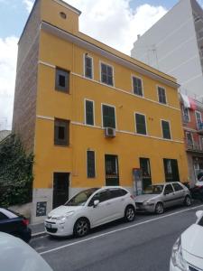 um edifício amarelo com carros estacionados em frente em Apartment Urbino 33 em Roma