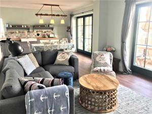 ein Wohnzimmer mit einer Couch und Stühlen und einem Tisch in der Unterkunft Schippers Butz strandnah mit Whirpool in Ostseebad Karlshagen