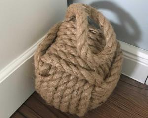 a large rope ball sitting on the floor next to a wall at Schippers Butz strandnah mit Whirpool in Ostseebad Karlshagen
