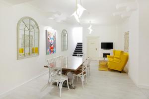 ein Esszimmer mit einem Tisch und gelben Stühlen in der Unterkunft Excelsior Boutique Hotel Sinaia in Sinaia