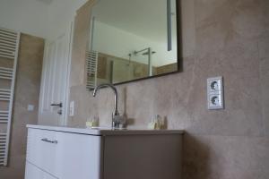 La salle de bains est pourvue d'un lavabo et d'un miroir. dans l'établissement Ferienwohnung Boskop, à Stade