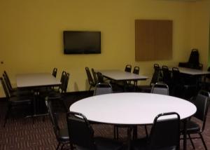 a room with tables and chairs and a television at Microtel Inn & Suites by Wyndham Delphos in Delphos