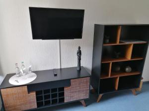 ein Modell eines Badezimmers mit einem Waschbecken und einem TV in der Unterkunft Gasthof-Hotel Biedendieck in Warendorf