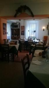 comedor con mesas y sillas y sala de estar en La Favorita, en Lozzo Cadore