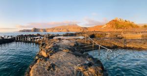 a group of rocks in the water near the ocean at Occidental Roca Negra - Adults Only in Agaete