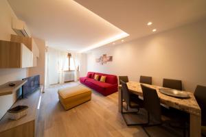 sala de estar con sofá rojo y mesa en Blue Moon - Via Parigi Apartments, en Aosta