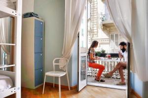 a man and woman sitting at a table in a dorm room at Grand Hostel Manin in La Spezia
