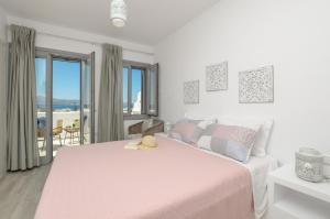 Habitación blanca con cama rosa y balcón. en Irianna of Naxos, en Agia Anna de Naxos 26 fotos más