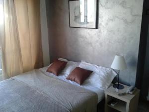 a bedroom with a bed with two pillows and a lamp at Hotel Riviera Sanremo in Sanremo