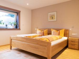 a bedroom with a bed with yellow pillows and a window at Hoferpeterhof in Bad Peterstal-Griesbach