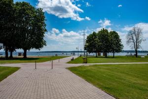 a walkway in a park next to the water at Apartament Molo in Giżycko