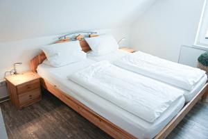 1 cama grande con sábanas y almohadas blancas en Bergkrönchen Winterberg - Sauna - 8Beds - outdoor en Winterberg